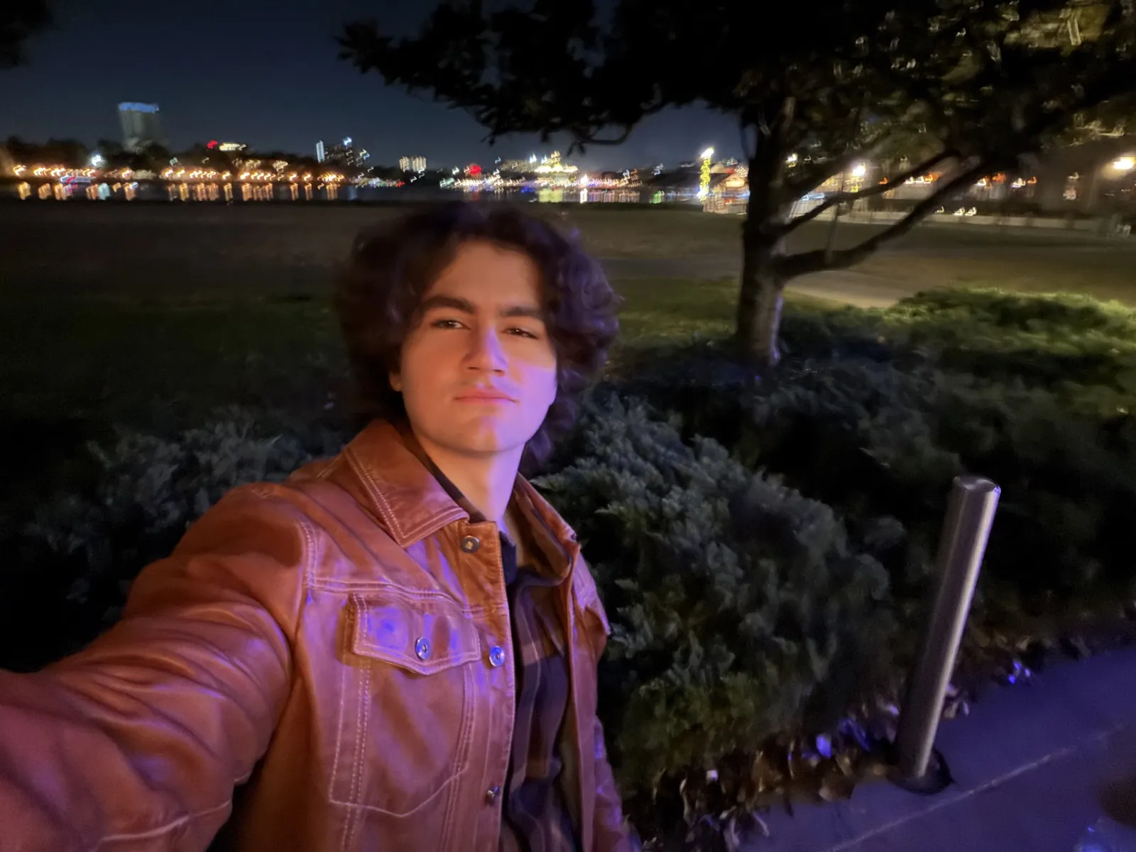 Daniel standing by the Toronto waterfront at night.