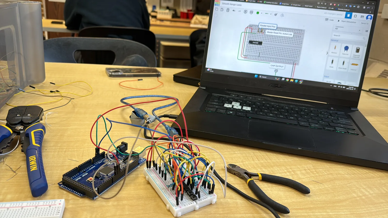 Daniel working among the wiring and electronics of a robotics project.